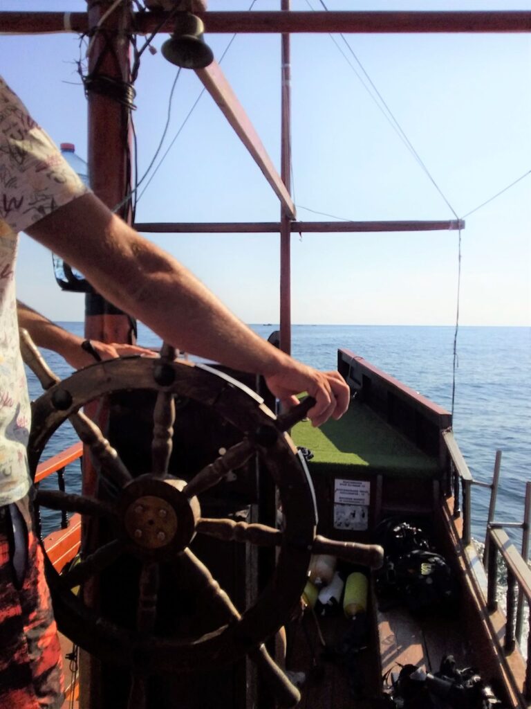 The captain at the wheel of our boat for diving shipwrecks in Sozopol, Bulgaria
